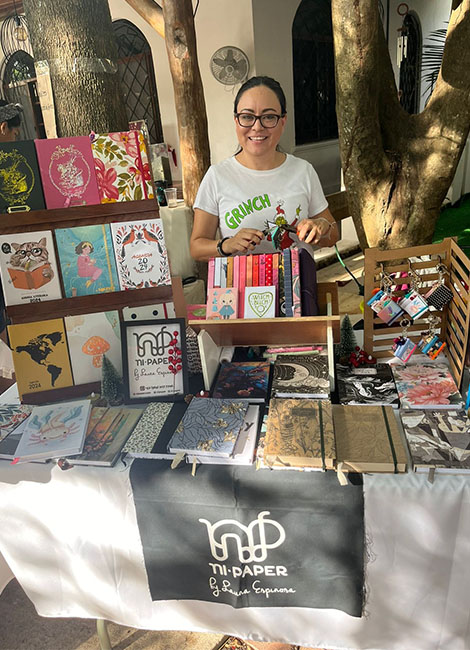 Fundadora de Ni Paper en su stand de mercado con libretas hechas a mano